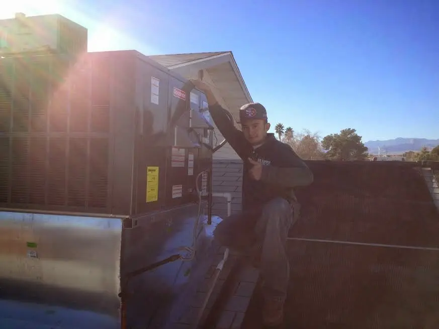 HVAC technician performing HVAC Inspection on a rooftop unit in Vinita